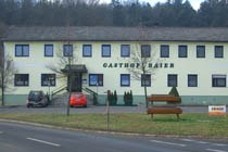 Ansicht des Gasthofes, im Vordergrund eine Bank.