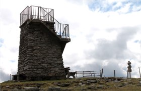 Steinerner Aussichtsturm mit Gel&auml;nder auf einem H&uuml;gel.