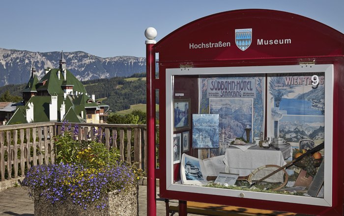 Schaukasten des Hochstra&szlig;enmuseums mit Berglandschaft im Hintergrund.
