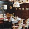 Gem&uuml;tliches Restaurant mit Holzw&auml;nden, rot gestreiften Sitzb&auml;nken und gedecktem Tisch.