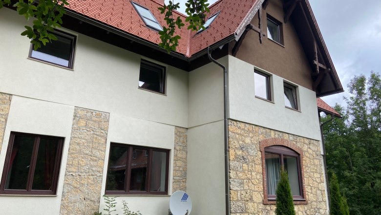 Oldaln&eacute;zet egy v&ouml;r&ouml;s tetővel &eacute;s kőfalazattal rendelkező vill&aacute;r&oacute;l.