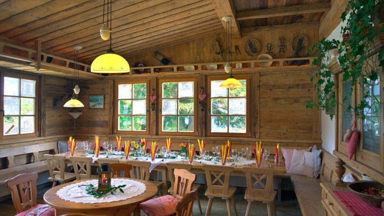 Gemütlicher Gastraum mit Holzmöbeln und dekoriertem Tisch.