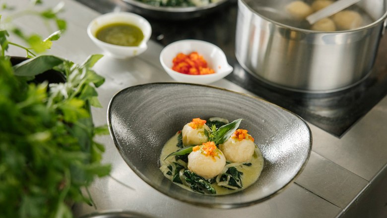 Kn&ouml;del sch&ouml;n angerichtet neben einer Herdplatte und einem Topf